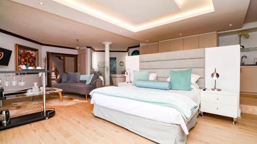 a bedroom with a large bed and a living room at Knysna Pearl View Guest House in Knysna