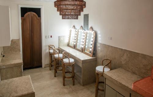a salon with a row of stools and a mirror at MiraNamin Nest LIRYO Suite in Unique Historic Home - Garden Access, Family Friendly, Shared Kitchen in Manila