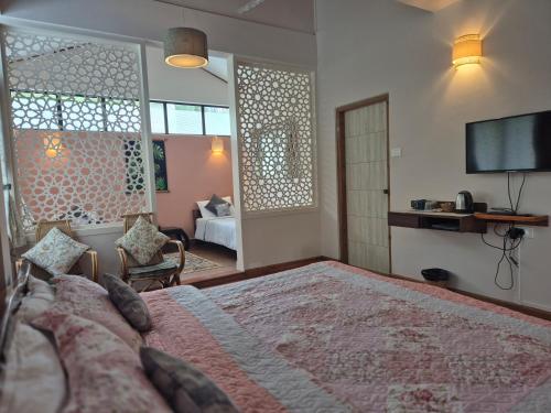 a bedroom with a large bed and a tv at Sha Ri Loum Homestay in Shillong