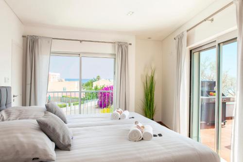een slaapkamer met een groot bed met twee knuffels erop bij Villa Santa Rosa by Algarve Vacation in Armação de Pêra