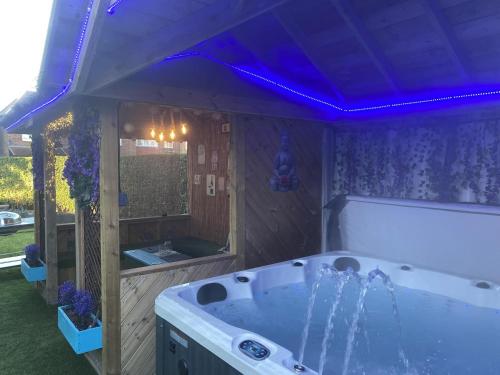 a bathroom with a tub with a purple lighting at 6 Bed-Sleeps 12-Hot Tub-Free Parking-Pet Friendly in Newcastle upon Tyne