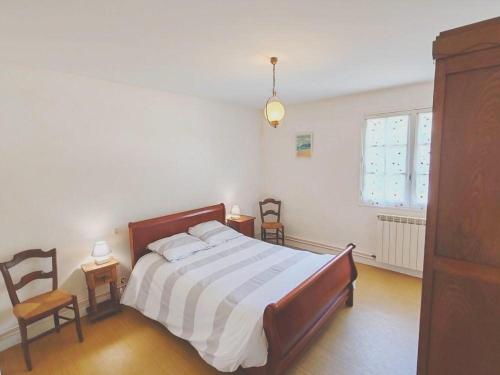 a bedroom with a bed and two chairs and a window at La poterie in Castets