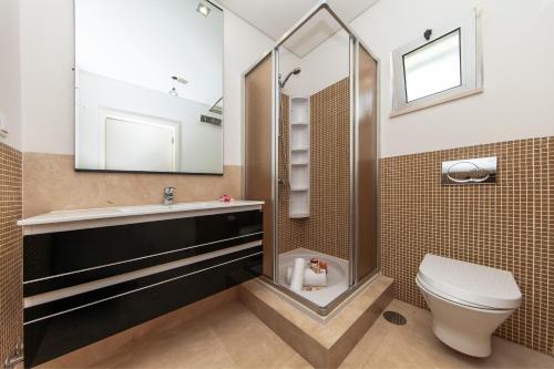 een badkamer met een toilet, een wastafel en een spiegel bij Villa Santa Rosa by Algarve Vacation in Armação de Pêra