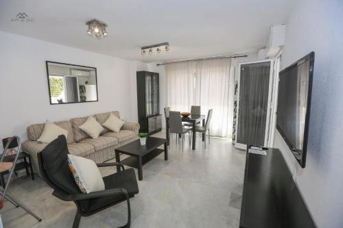 Una sala de estar con un sofá y sillas y una mesa. en Alcazaba Del Mar parking next to the beach, en La Herradura