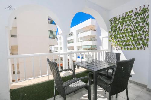 Un balcón con una mesa y sillas y un edificio. en Alcazaba Del Mar parking next to the beach, en La Herradura