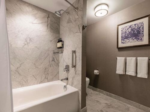 a bathroom with a white tub and a toilet at Fairmont Olympic Hotel in Seattle