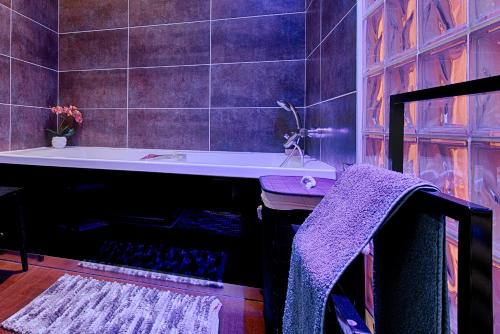 a bathroom with a bath tub and a sink at T3 Les Tilleuls Sermerieu in Sermérieu