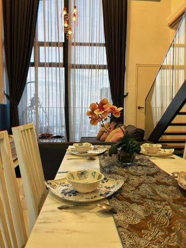 a dining room table with plates and dishes on it at MLH Designer Duplex Suite @ EkoCheras in Cheras
