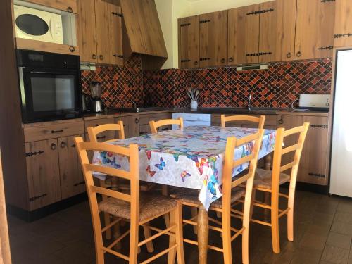 een keuken met een tafel met stoelen en een koelkast bij Ciboulette 2 in La Clusaz