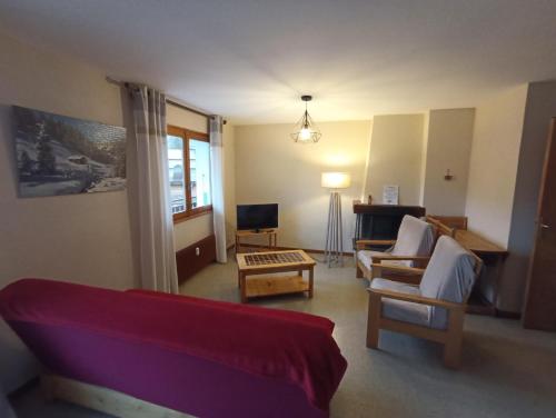 een woonkamer met een bank en een stoel bij Clair de Lune 2 in La Clusaz