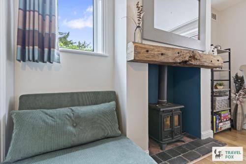 a living room with a couch and a wood stove at The Old Post Office 5 mins Drive to Alton Towers in Alton