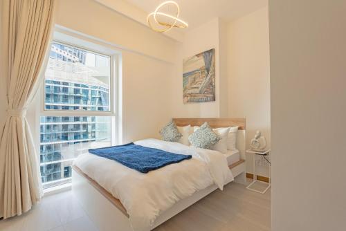 a bedroom with a bed and a large window at Luxury 1 & 2 BHK Apartments, Branded & State of The Art Amenities in Dubai