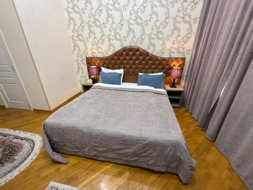 a bedroom with a large bed with blue pillows at Pilot By Haz Hotel in Baku
