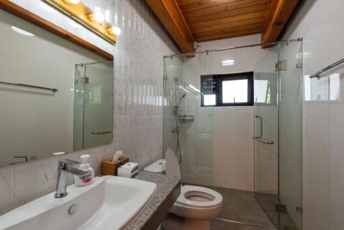 a bathroom with a toilet and a sink and a shower at Monlada Khaoyai in Mu Si