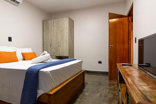 - une chambre avec un grand lit et une commode en bois dans l'établissement Nana Suites, à Foz do Iguaçu