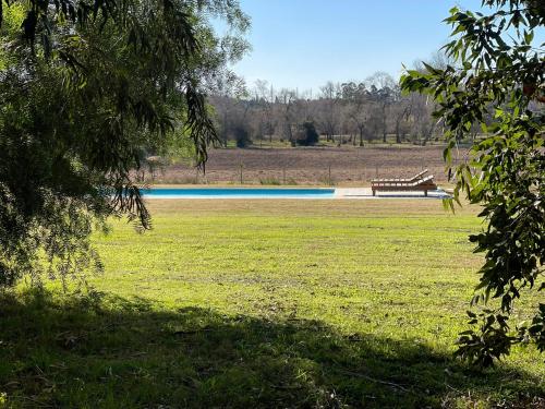 un parque con un banco en medio de un campo en Chacra La Margarita by Posada de la Flor, en Colonia del Sacramento