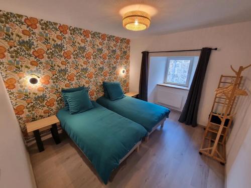 a bedroom with a green bed and a window at L'Ecole Buissonnière de Mazalibrand in Bronac