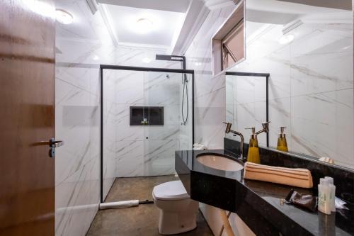 une salle de bain avec une douche en verre et un lavabo dans l'établissement Nana Suites, à Foz do Iguaçu