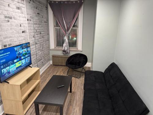 a living room with a couch and a tv at Cozy apartment on Richmond st London Downtown in London
