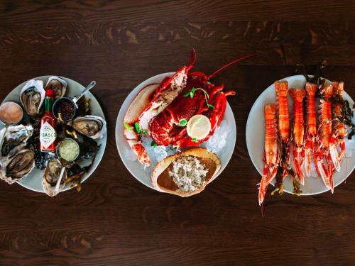 three plates of seafood and vegetables on a table at Fairmont St Andrews, Scotland in St. Andrews