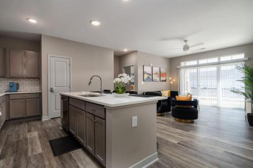 a kitchen with a sink and a living room at Cozy Lux Haven Whitestown in Whitestown