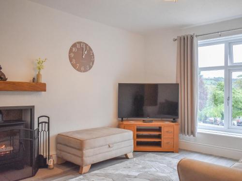 Una sala de estar con un televisor de pantalla plana en una pared. en Ryecroft, en Matlock