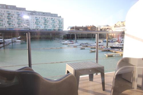 a balcony with a view of a marina with a table and chairs at Fabulous Waterfront Apartment in Brighton Marina in Brighton & Hove