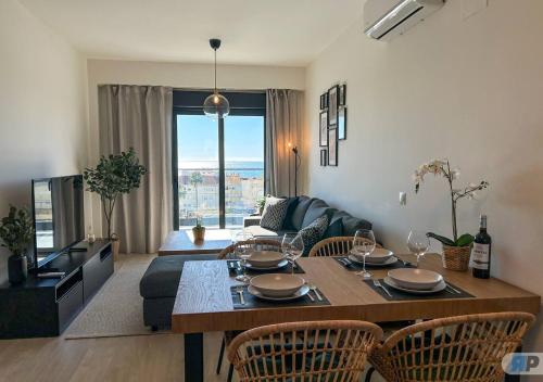 a living room with a table with chairs and a couch at Apartamento Orizon con terraza y vistas al mar 003 in Algarrobo-Costa