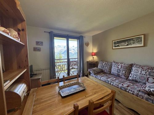 a living room with a couch and a table at Studio confortable avec balcon à 400m des pistes - Auris en Oisans - FR-1-297-138 in Auris