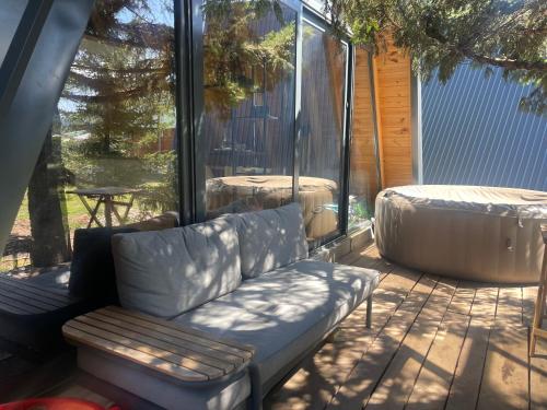 a couch sitting on a screened in porch at PeaksView Chalets in Žabljak