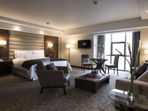 a hotel room with a bed and a living room at Swissotel Lima in Lima