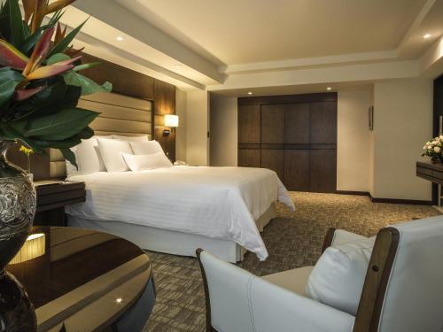 a hotel room with a bed and a table and chairs at Swissotel Lima in Lima