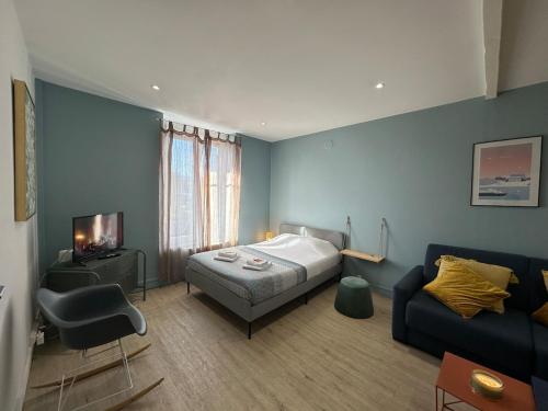 a bedroom with a bed and a couch at C Oslo - Appartement spacieux proche centre-ville in Charleville-Mézières