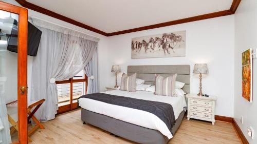 a bedroom with a large bed and a window at Knysna Pearl View Guest House in Knysna