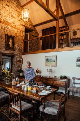 Una mujer parada en una gran mesa de madera en una habitación. en The Granary Wales, en Kington