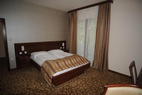 um quarto de hotel com uma cama e uma janela em Hotel Balkana Vidović em Mrkonjic Grad