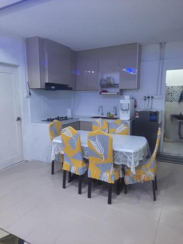 a kitchen with a table and chairs in a kitchen at Homestay Ezy Nano in Kampong Machang Gedibing