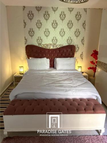 une chambre avec un grand lit avec une tête de lit rouge dans l'établissement Paradise Gates Madinaty, à Madinaty