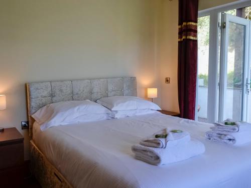 a bedroom with a bed with towels on it at Seaviews And Hot Tub At The Fairways - Uk39821 in Portpatrick