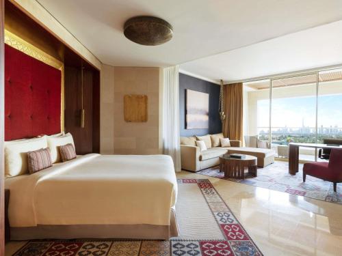 a bedroom with a large bed and a living room at Raffles Dubai in Dubai