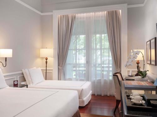 Postel nebo postele na pokoji v ubytování Raffles Hotel Le Royal