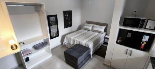 a small bedroom with a bed and a tv at Xavi Studio in Bauru