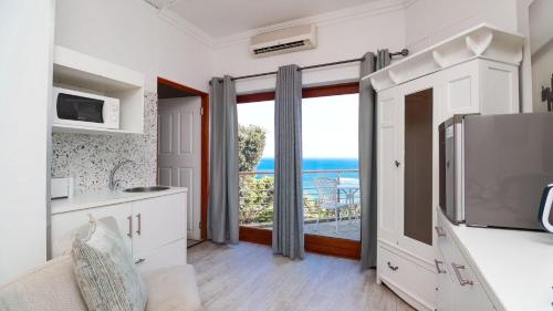 a kitchen with a large window with a view of the ocean at Knysna Pearl View Guest House in Knysna