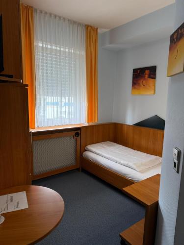 a small room with a bed and a window at SVG Hotel Diversi in Ludwigshafen am Rhein