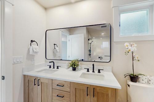 Un baño con lavabo y un espejo grande. en South Lakeshore Waterfront Oasis, en Chelan