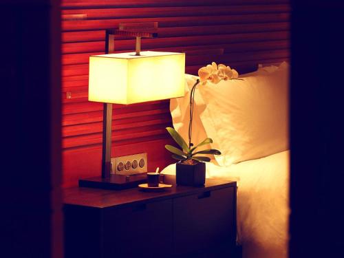 a lamp on a night stand next to a bed at Raffles Hainan Clear Water Bay in Sanya