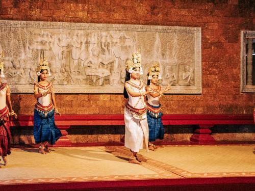 a group of women in crowns standing in front of a wall at Raffles Grand Hotel d'Angkor in Siem Reap