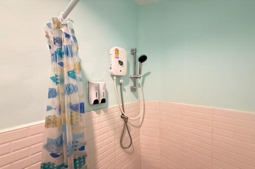 a shower with a blow dryer and a shower curtain at Scala Hostel in Bangkok
