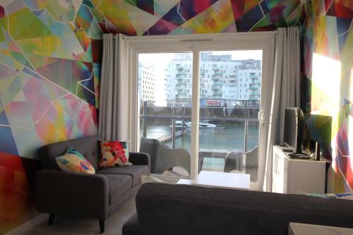 a living room with a couch and a window at Fabulous Waterfront Apartment in Brighton Marina in Brighton & Hove