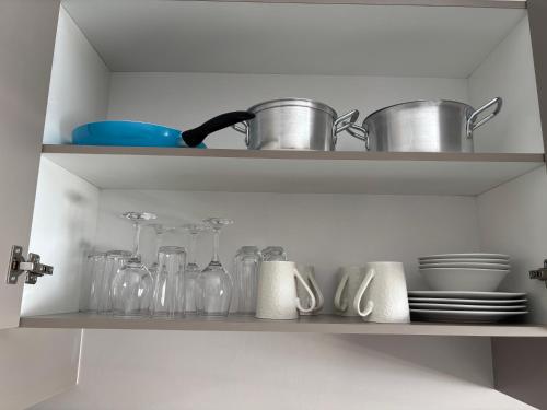 a kitchen shelf with pots and pans and dishes at Tranquil Stays in Polokwane